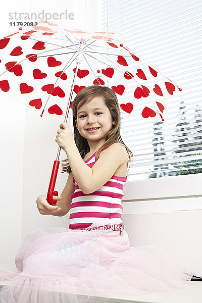 Porträt eines lächelnden Mädchens mit Regenschirm