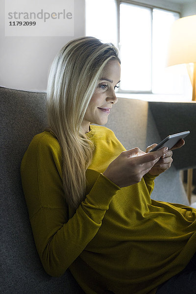 Porträt einer Frau auf der Couch mit Mini-Tablette