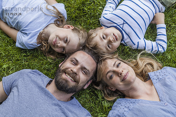 Porträt einer glücklichen Familie auf der Wiese liegend