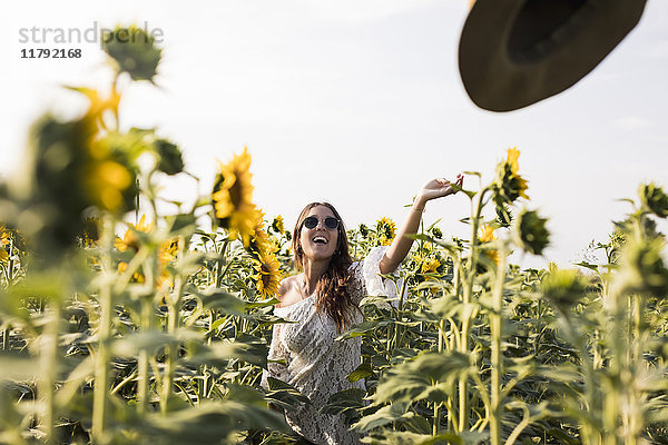 Glückliche Frau im Sonnenblumenfeld