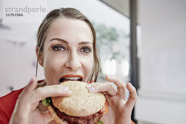Frau beim Essen eines veganen Hamburgers