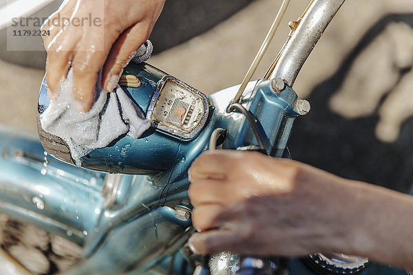 Nahaufnahme einer Frau bei der Reinigung von Oldtimermotorrädern