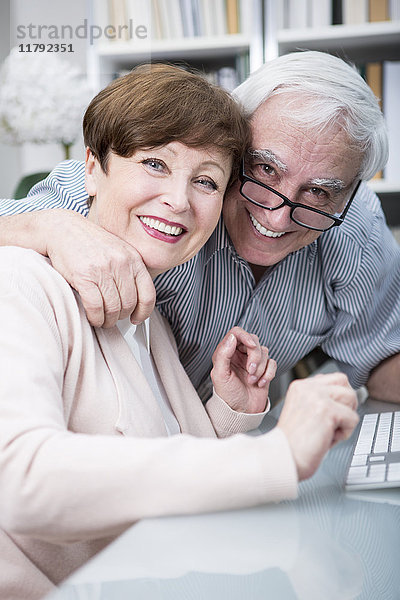 Seniorenpaar umarmt und lächelt vor der Kamera