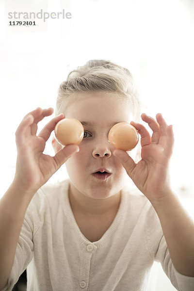 Porträt eines kleinen Mädchens mit zwei braunen Eiern