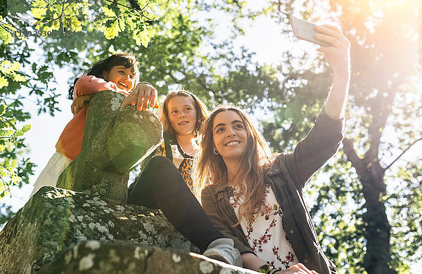 Drei glückliche Mädchen  die mit einem Selfie nach draußen gehen.