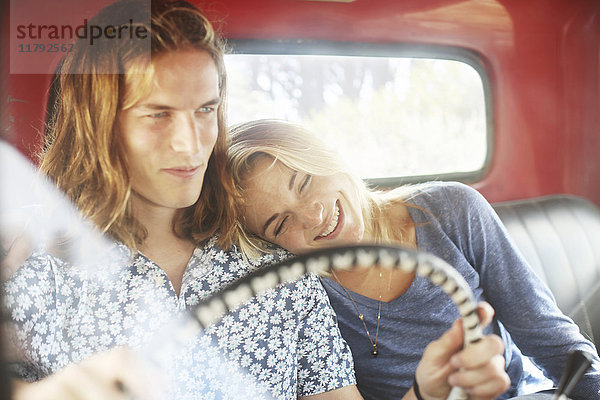 Lächelndes junges Paar in einem alten Pick-Up