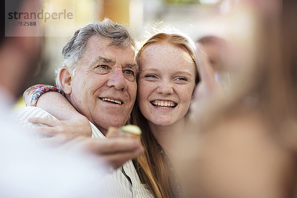 Enkelin umarmt Großvater im Freien