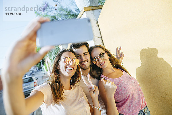 Freunde  die einen Selfie mit Smartphone auf die Straße nehmen