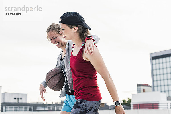 Zwei glückliche Frauen mit Basketball in der Stadt