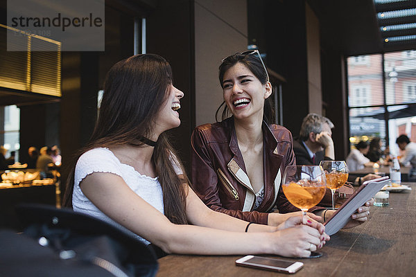 Zwei glückliche junge Frauen in einer Bar