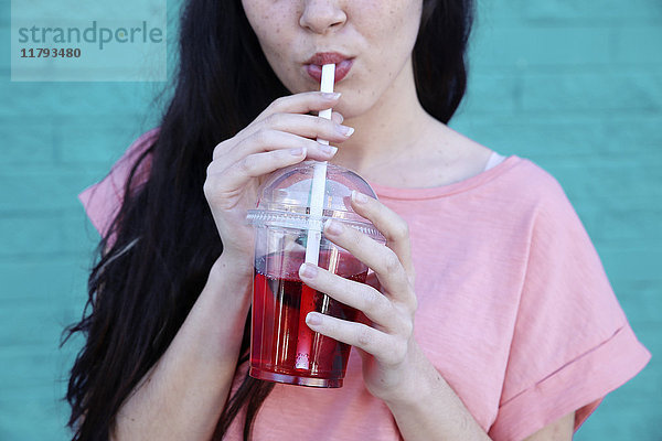 Junge Frau trinkt Erfrischungsgetränk  Teilansicht