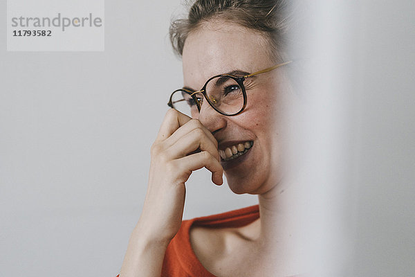 Porträt einer glücklichen jungen Frau mit Brille