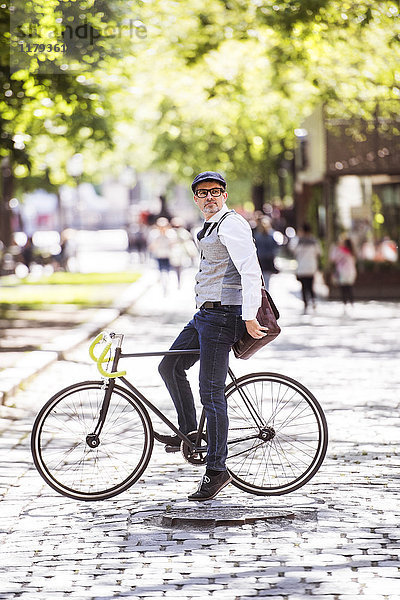Erwachsener Geschäftsmann auf dem Fahrrad in der Stadt