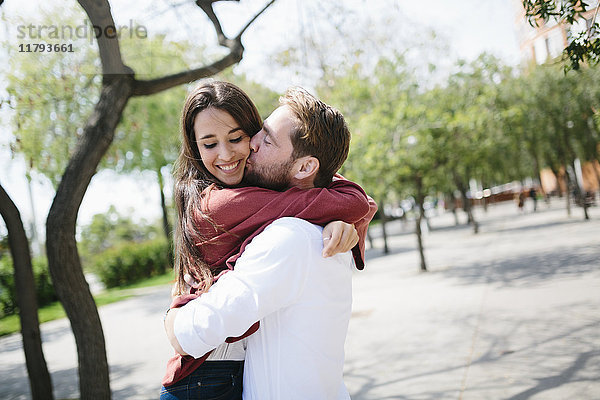 Ein glückliches Paar  das sich auf der Straße küsst und umarmt.