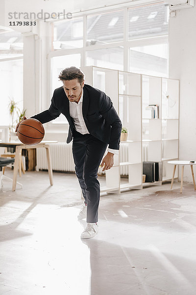 Geschäftsmann spielt Basketball im Büro