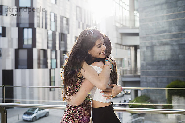 Zwei glückliche junge Frauen  die sich in der Stadt umarmen.