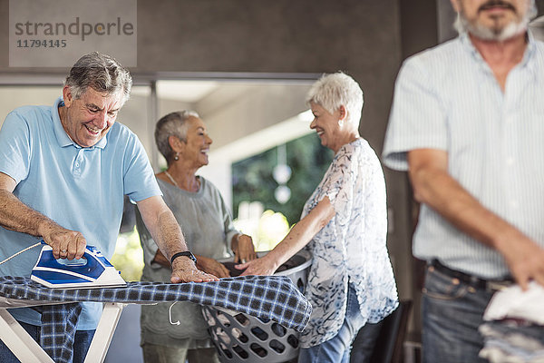 Senioren bügeln Kleidung zusammen