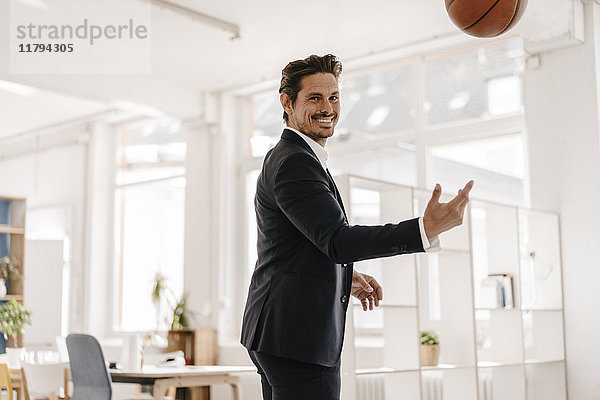 Geschäftsmann spielt Basketball im Büro
