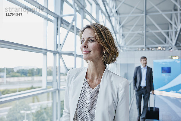 Zuverlässige Geschäftsfrau am Flughafen mit Blick aus dem Fenster
