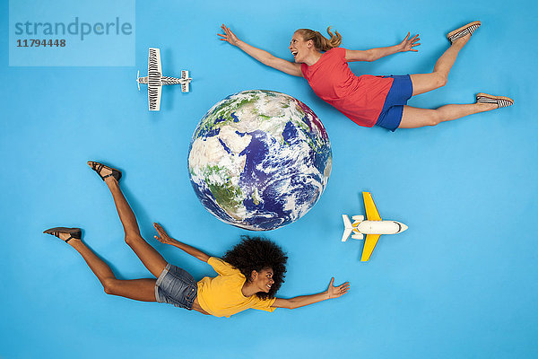 Zwei Frauen und Flugzeuge  die um den Globus fliegen.