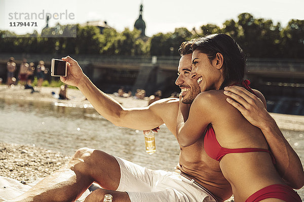 Verliebtes Paar nimmt Selfie am Strand mit.