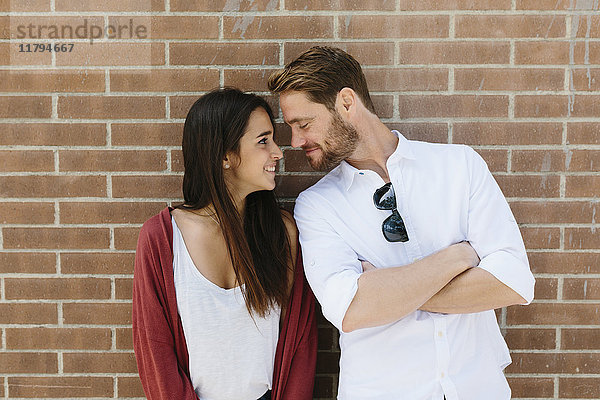 Glückliches Paar  das vor der Mauer steht und sich küsst.