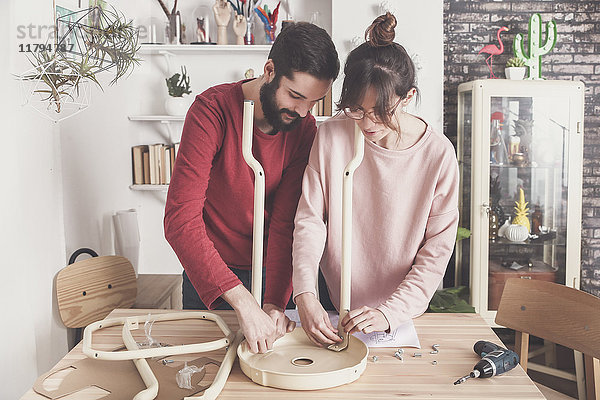 Junges Paar beim Zusammenbau von Flat-Pack-Hocker zu Hause