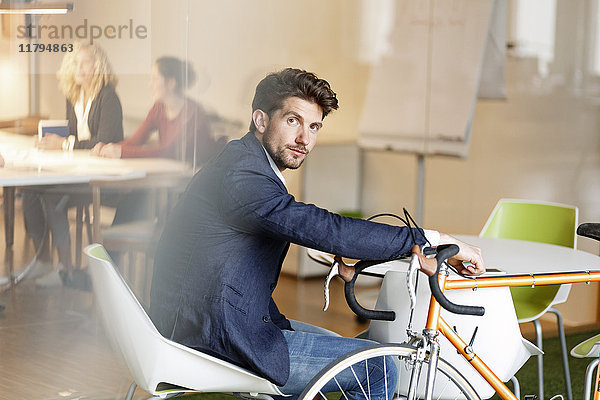 Geschäftsmann mit Fahrrad im Büro