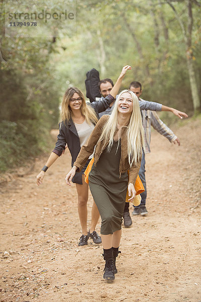Vier glückliche Freunde  die sich auf dem Weg durch den Wald amüsieren.