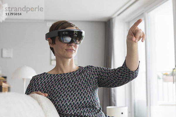 Frau zu Hause mit Augmented Reality Brille zu Hause