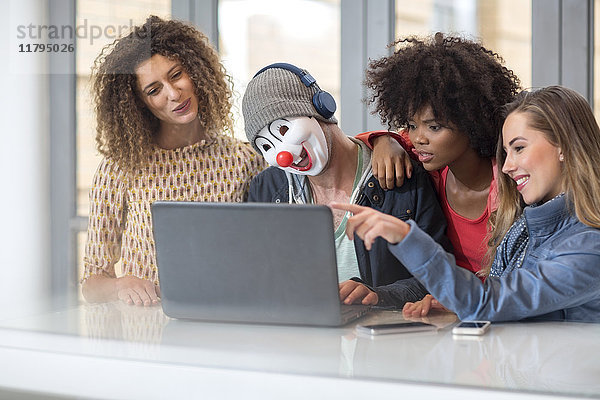 Mann im Büro trägt Maske teilen Laptop mit Kollegen