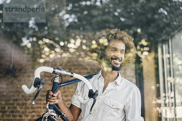 Lächelnder junger Mann mit Fahrrad