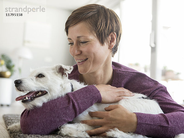 Frau umarmt ihren Hund zu Hause