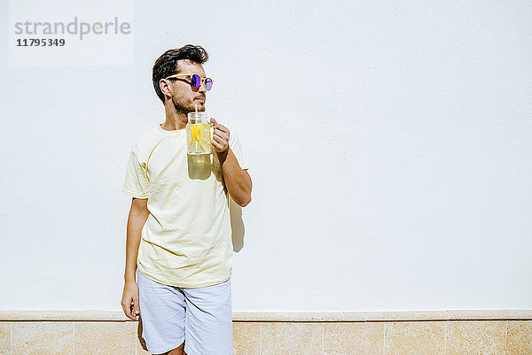 Mann mit Sonnenbrille und Limonade in weißer Vorderwand