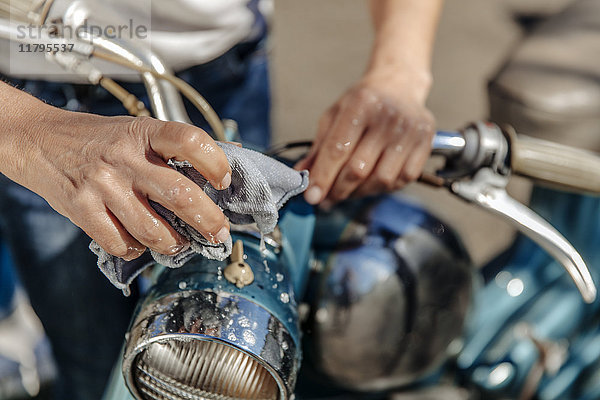 Nahaufnahme einer Frau bei der Reinigung von Oldtimermotorrädern