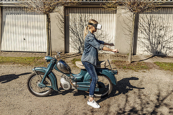 Frau mit Vintage-Motorrad mit VR-Brille