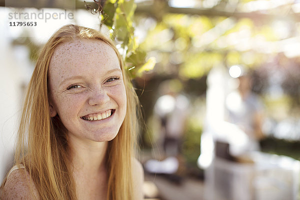 Porträt eines glücklichen Mädchens mit langen roten Haaren