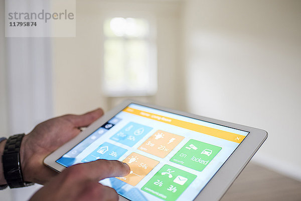 Mann im neuen Zuhause mit Tablet mit Smart Home Apps