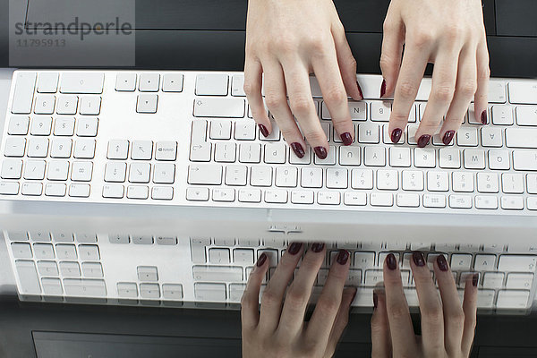 Weibliche Hände beim Tippen auf der Tastatur