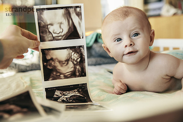 Baby wird mit frühen 3D-Ultraschallbildern von sich selbst verglichen.