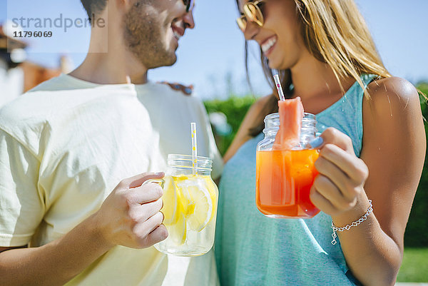 Paar mit erfrischenden Getränken im Freien