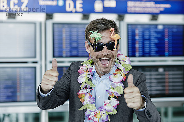 Glücklicher Geschäftsmann verkleidet als Tourist am Flughafen