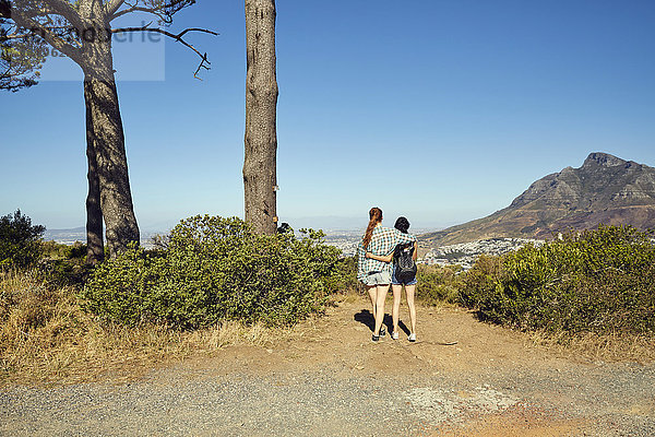 Südafrika  Kapstadt  Signal Hill  zwei junge Frauen mit Blick auf die Stadt