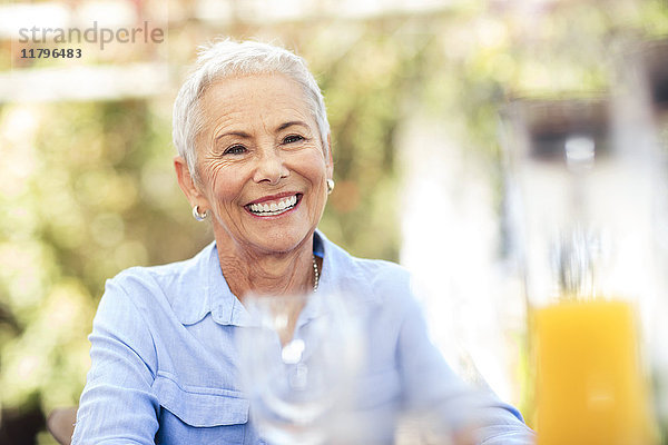 Porträt einer lächelnden Seniorin im Freien