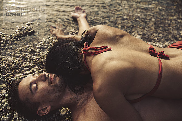 Verliebtes Paar entspannt sich gemeinsam am Strand