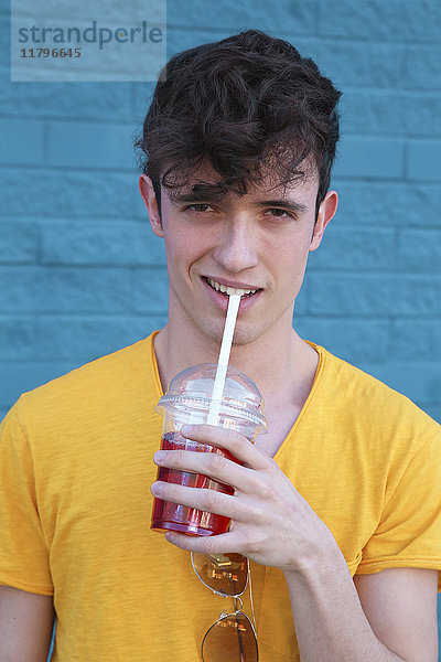 Porträt eines jungen Mannes  der Erfrischungsgetränk trinkt