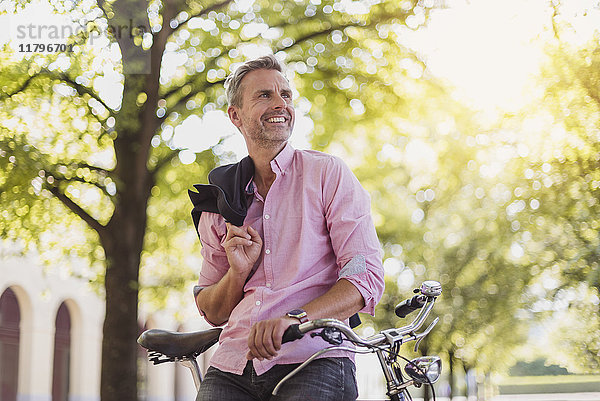 Lächelnder Mann mit Fahrrad im Park
