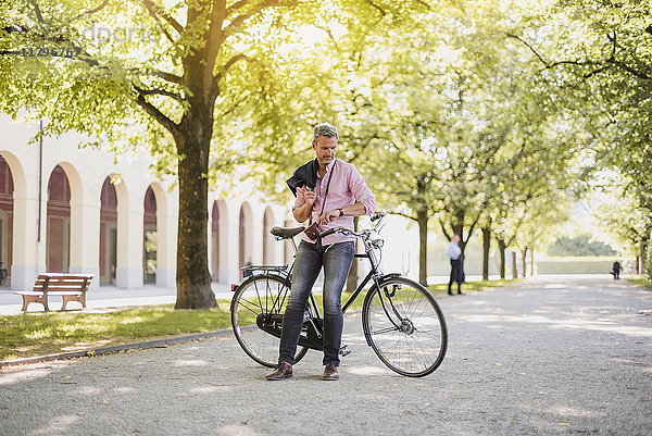Mann mit Fahrrad im Park bei einer Pause