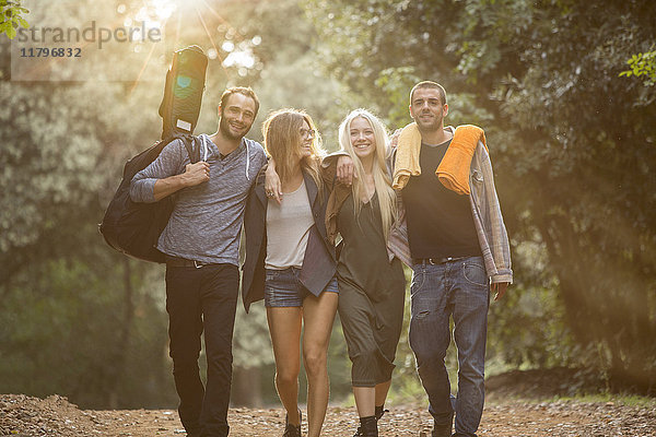 Vier glückliche Freunde  die im Wald spazieren gehen.