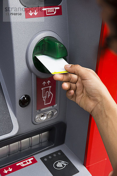 Hand der Frau beim Schieben der Kreditkarte am Geldautomaten  Nahaufnahme